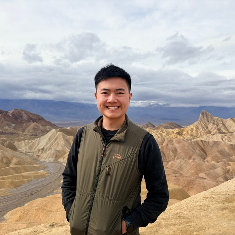 Henry Hung standing outdoors in Death Valley, badlands in the background